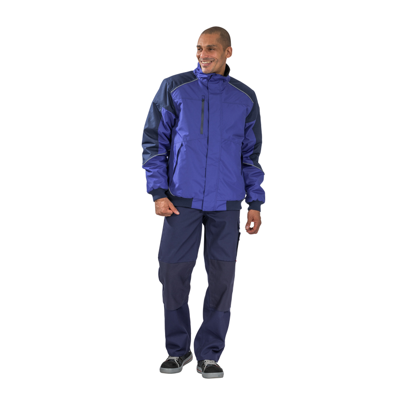 Mann trägt den Planam Desert Blouson wasserdichter Wetterschutz in Blau – robuste, wasserdichte Arbeitsjacke mit hohem Kragen und Reißverschluss