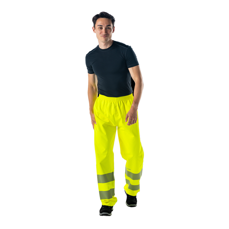 Männliches Model trägt eine Planam Warnschutzhose in Neon-Gelb mit umlaufenden Reflexstreifen an den Beinen vor weißem Hintergrund.