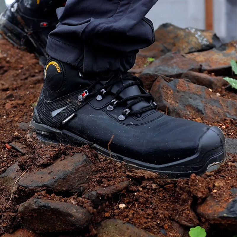 Giasco 3Ultra Defender New Sicherheitsstiefel extra robust S7S, schwarzer robuster Arbeitsstiefel im Einsatz auf nassem, steinigem Untergrund