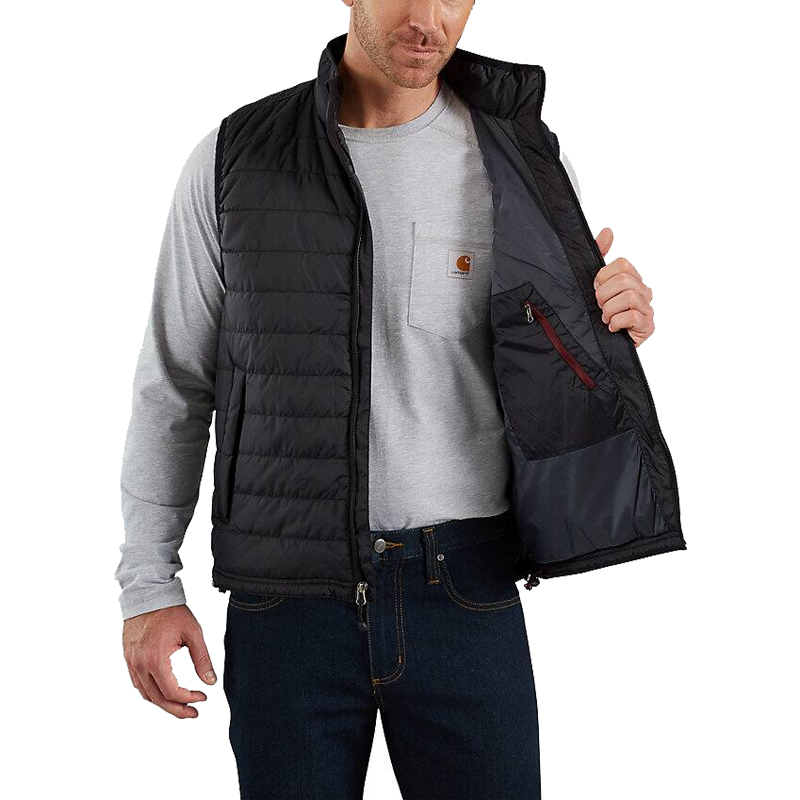 Herren tragen die schwarze Carhartt 102286 Gilliam Steppweste aus leichtem Gewebe im relaxed fit, geöffnet mit sichtbarer Innentasche
